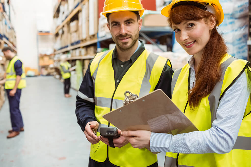 Man and woman warehouse workers with clipboard